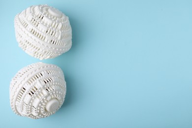 Laundry dryer balls on light blue background, flat lay. Space for text