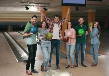 Group of friends with balls in bowling club