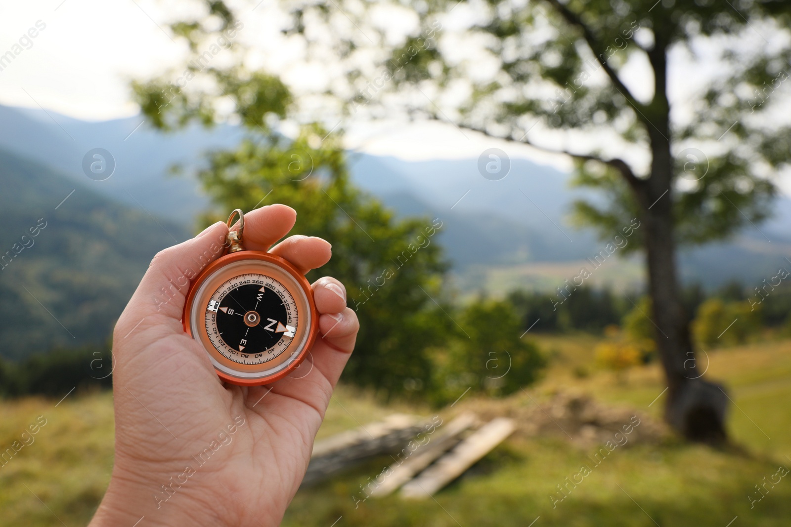 Photo of Woman using compass for navigation during journey in mountains, closeup