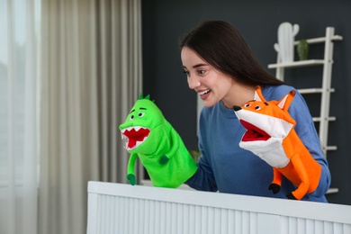 Young woman performing puppet show at home