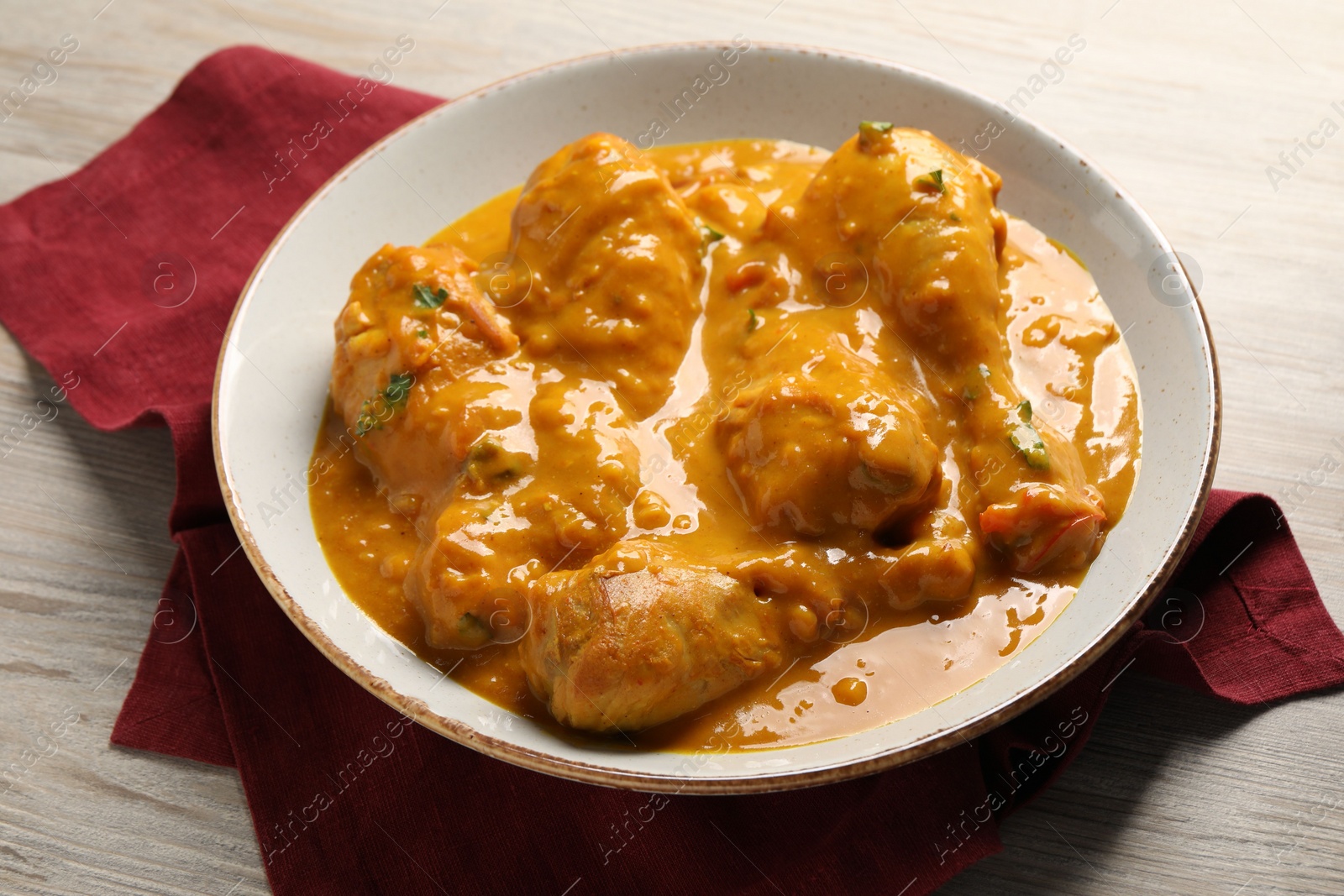 Photo of Tasty fresh chicken curry on wooden table