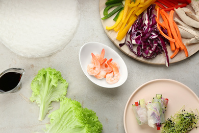 Photo of Dry rice paper and ingredients on light grey table, flat lay