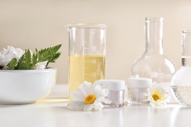 Photo of Skin care products, ingredients and laboratory glassware on table. Dermatology research