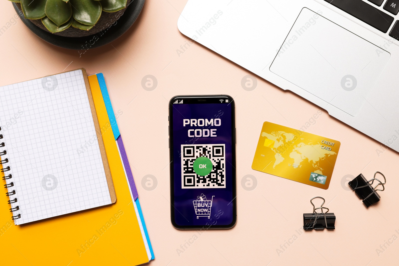 Photo of Smartphone with activated promo code, credit card and stationery on beige table, flat lay