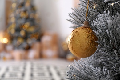 Photo of Beautiful Christmas tree decorated with ball in stylish room interior, closeup. Space for text