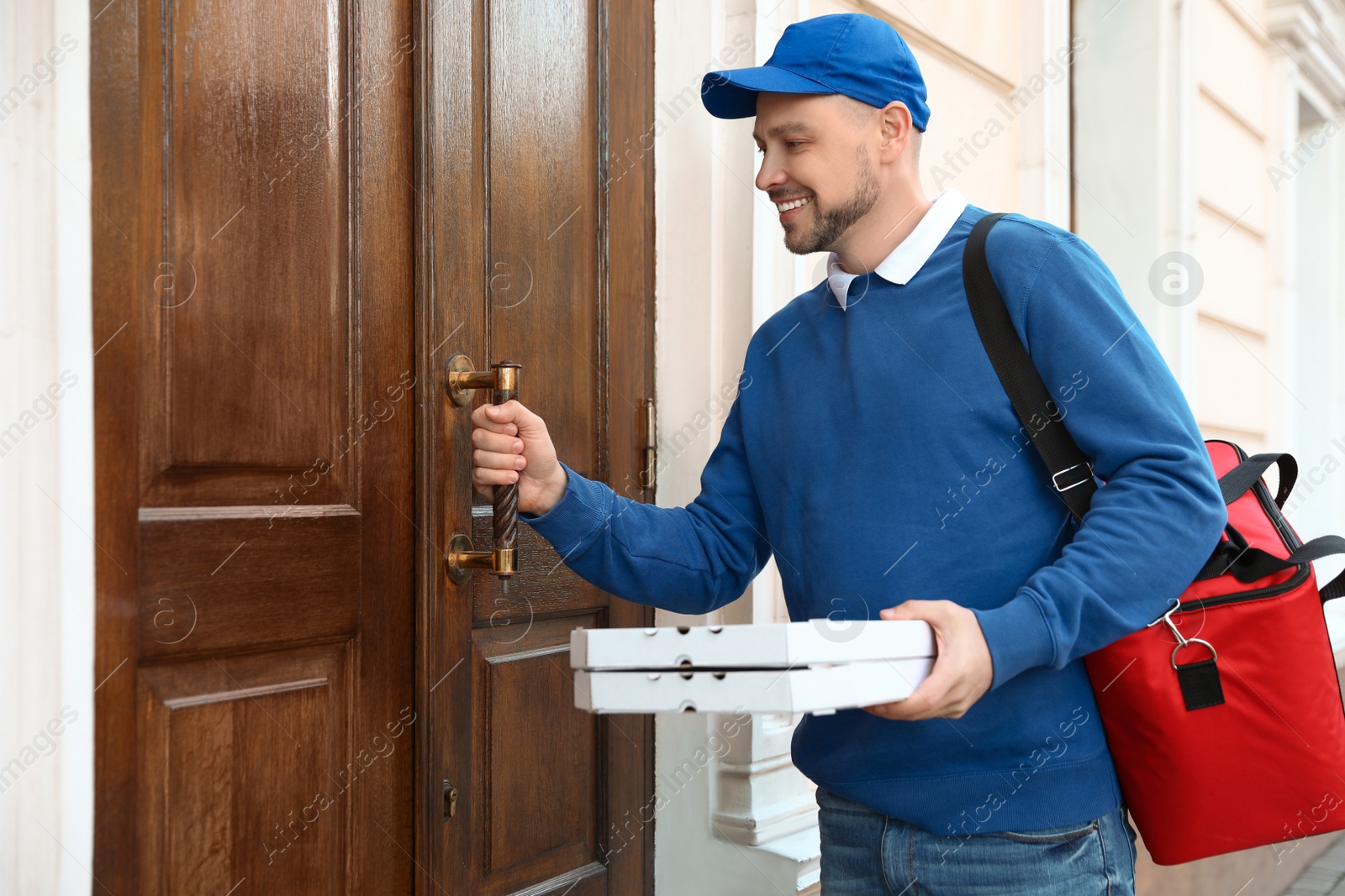 Photo of Male courier with order at entrance. Food delivery service