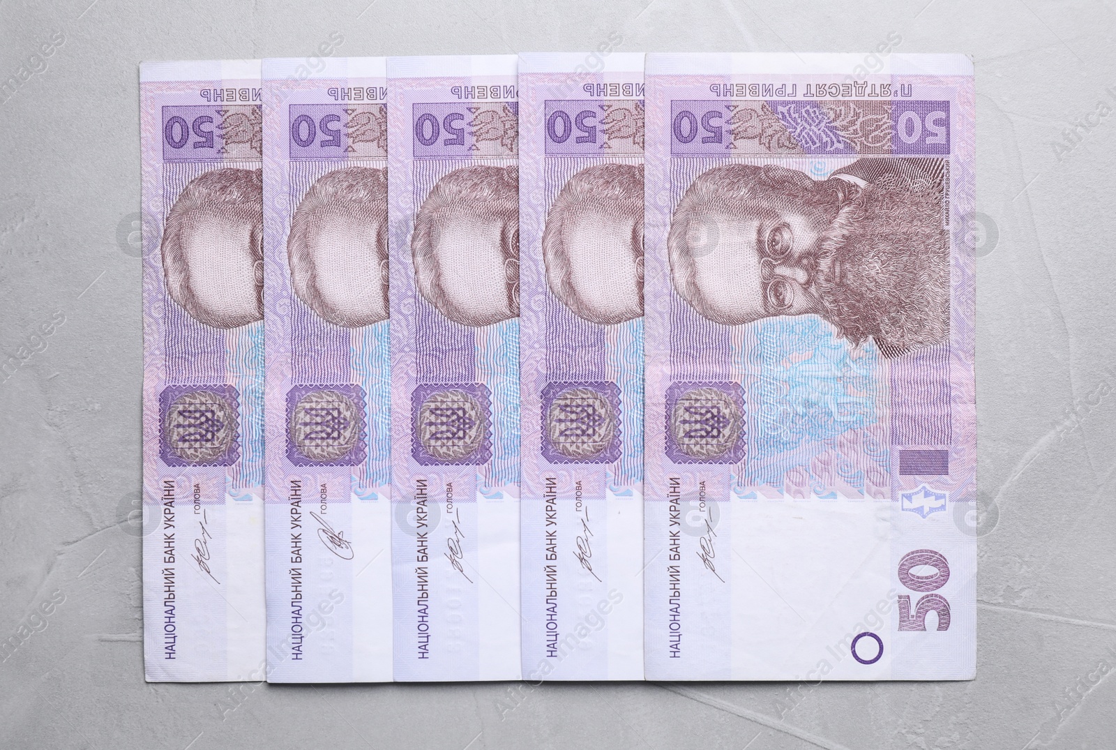 Photo of Ukrainian money on grey background, flat lay