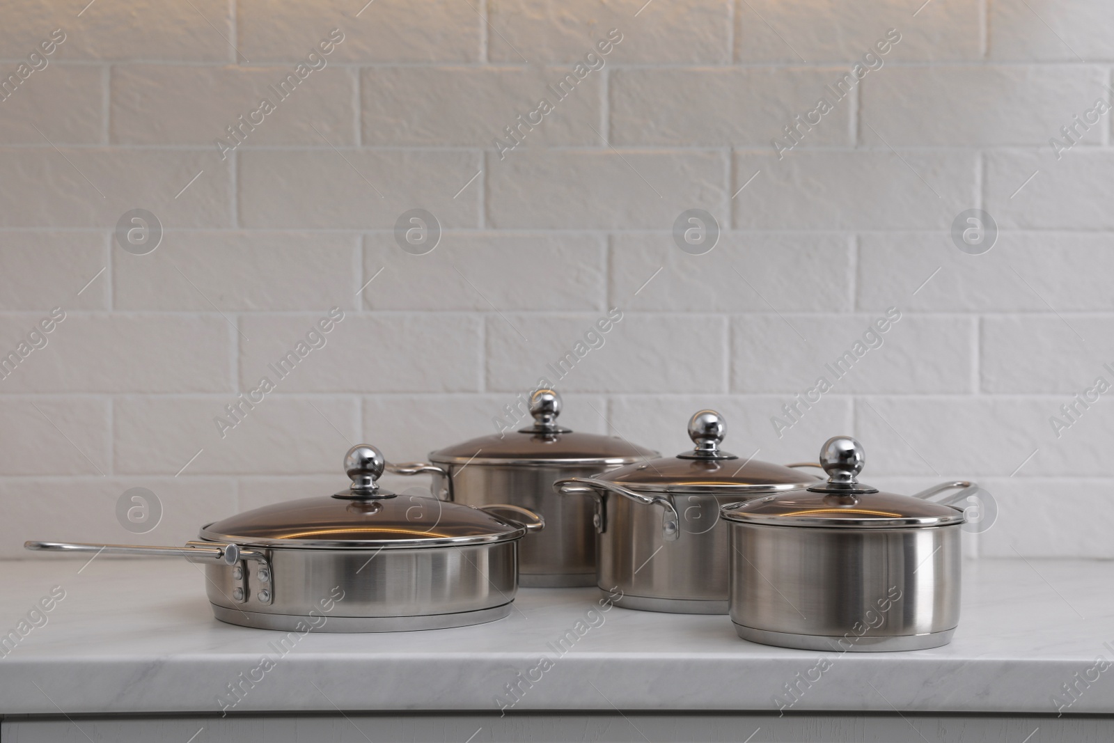 Photo of Set of new clean cookware on countertop in kitchen