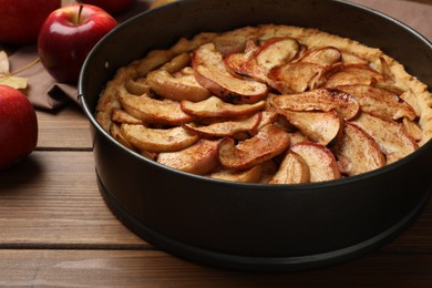 Delicious apple pie and fresh fruits on wooden table, closeup