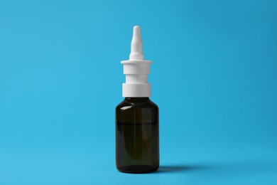 Bottle of nasal spray on light blue background