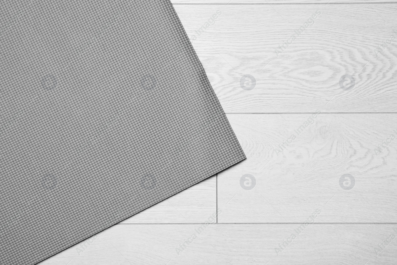 Photo of Grey sports mat on wooden background, top view with space for text