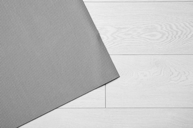 Grey sports mat on wooden background, top view with space for text