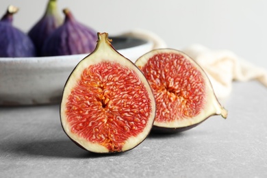 Photo of Fresh ripe fig sliced in half on table. Tropical fruit