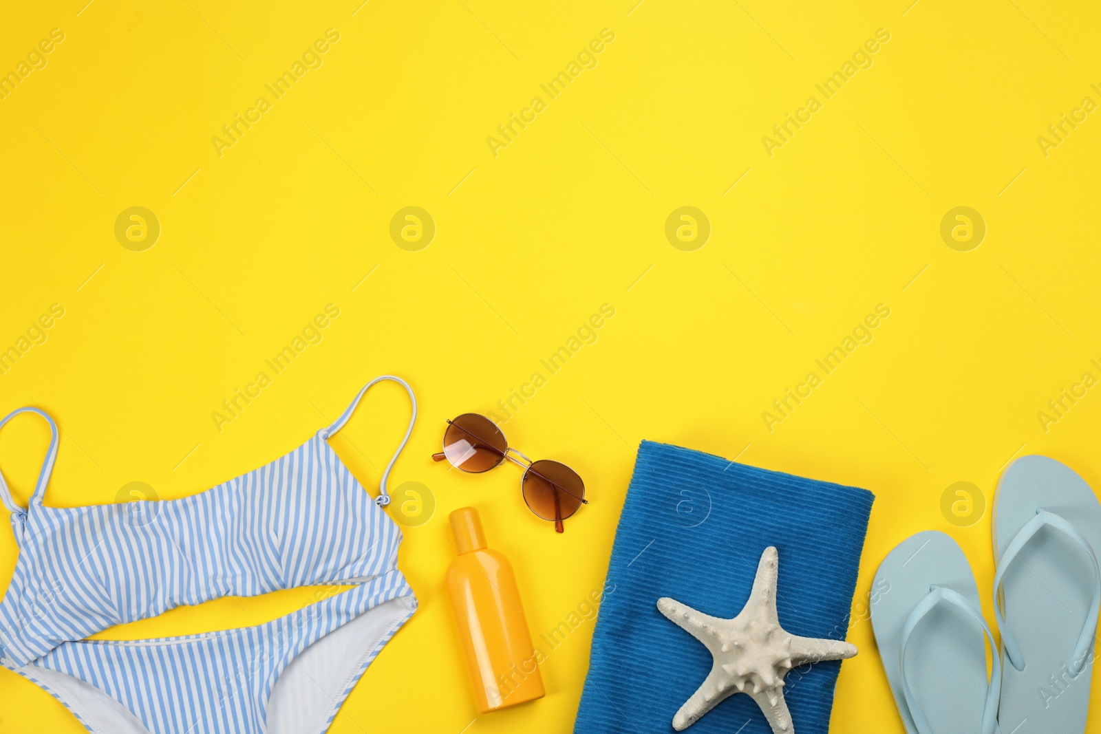 Photo of Flat lay composition with beach objects on yellow background, space for text