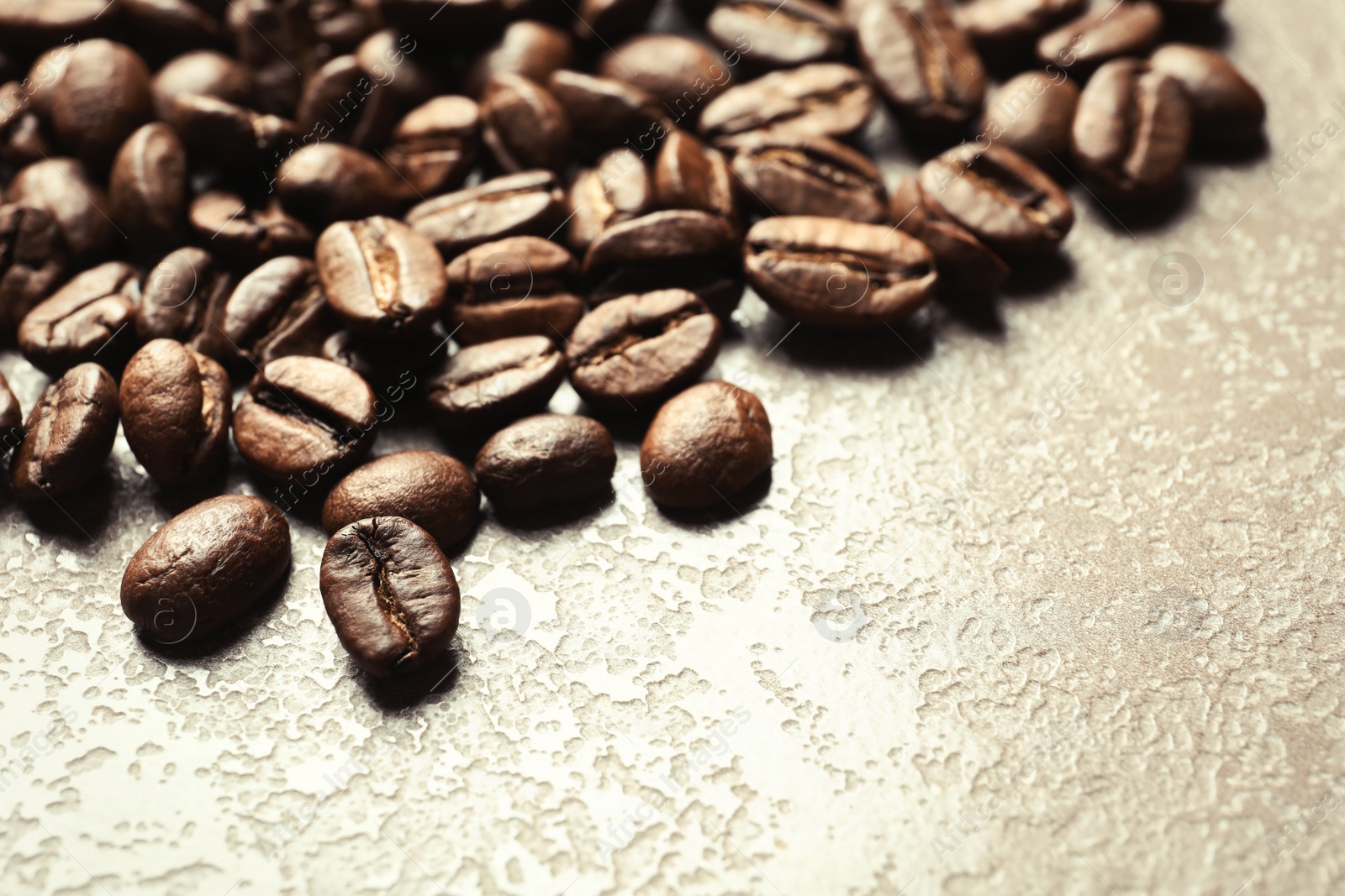 Photo of Roasted coffee beans on grey background with space for text, closeup