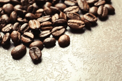 Roasted coffee beans on grey background with space for text, closeup