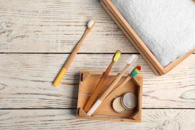 Flat lay composition with bamboo toothbrushes on wooden background