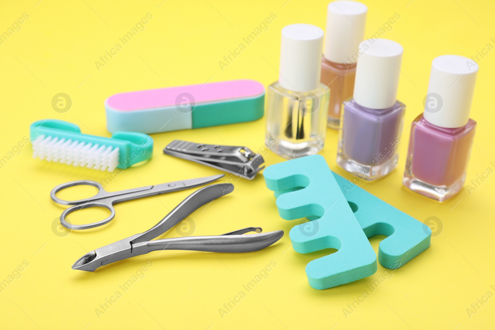 Photo of Set of pedicure tools on yellow background