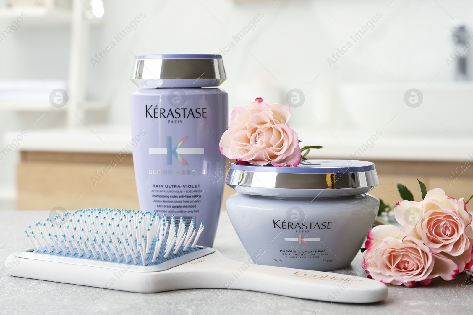 Photo of MYKOLAIV, UKRAINE - SEPTEMBER 07, 2021: Kerastase hair care cosmetic products and brush on light table in bathroom