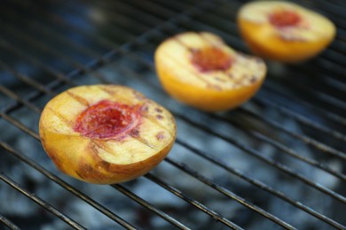 Photo of Modern grill with tasty cut peaches, closeup