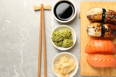 Delicious nigiri sushi served on light grey marble table, flat lay. Space for text