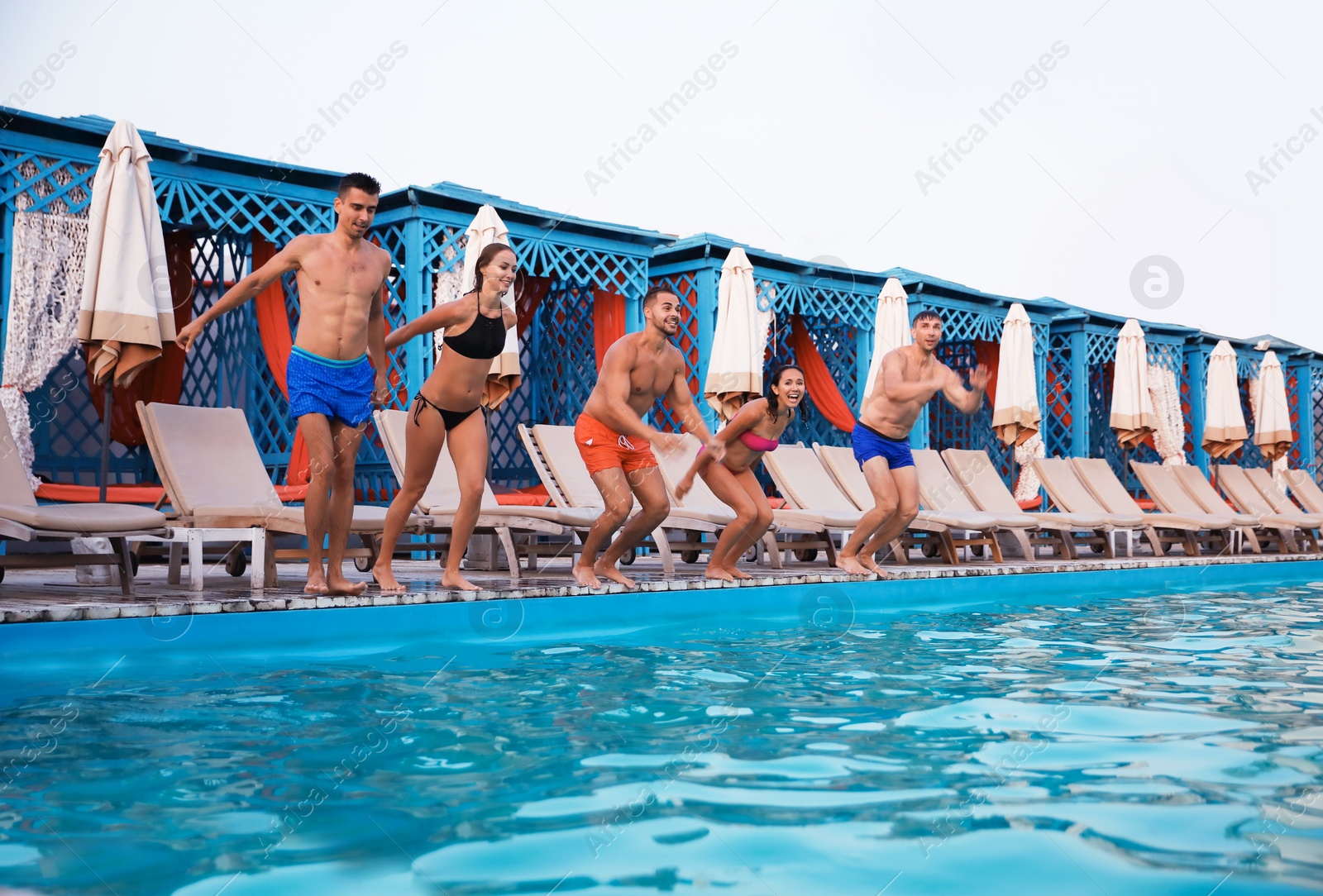 Photo of Happy young friends jumping in swimming pool