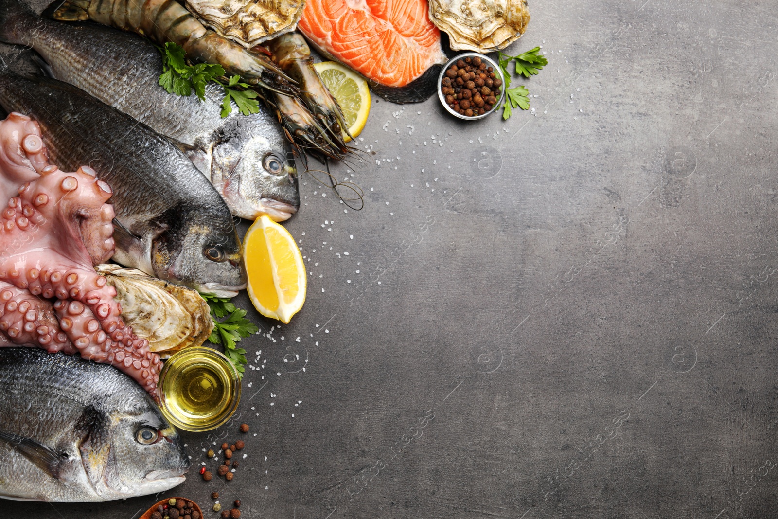 Photo of Flat lay composition with fresh raw dorado fish and different seafood on grey table. Space for text