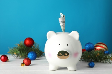 Composition with piggy bank, money and Christmas decor on table