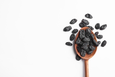 Photo of Spoon with raisins and space for text on white background, top view. Dried fruit as healthy snack