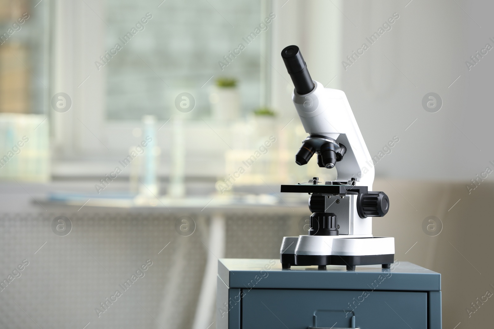 Photo of Modern medical microscope on drawer in laboratory, space for text