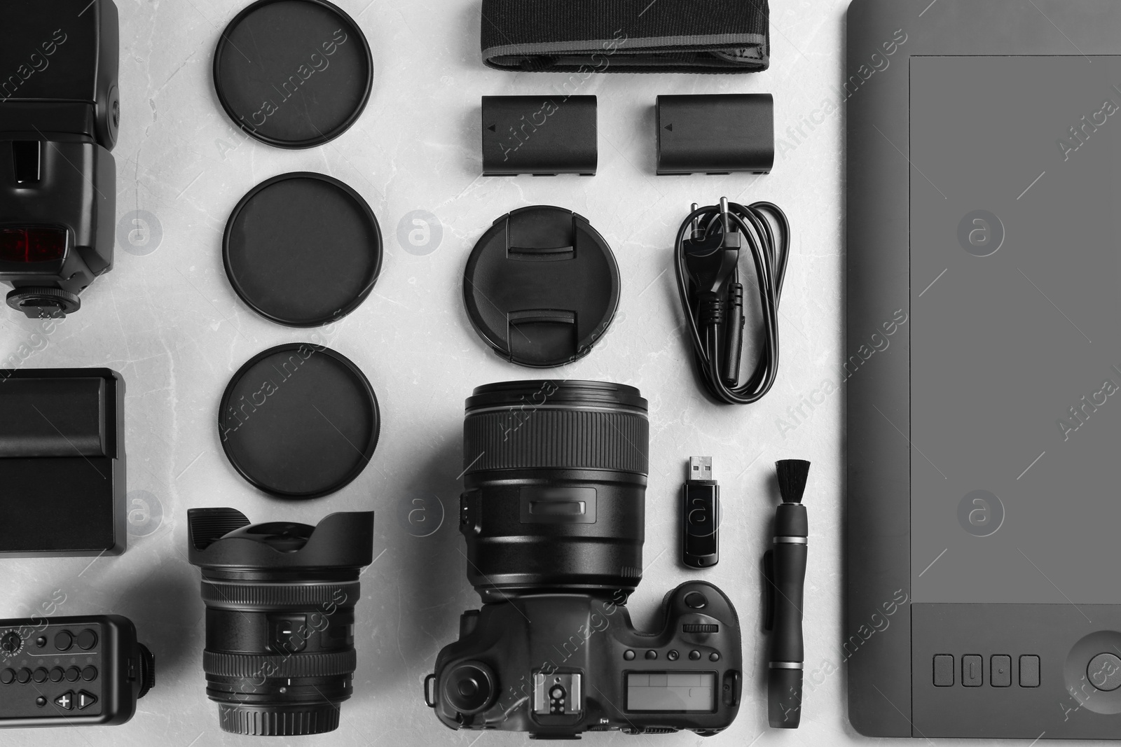 Photo of Flat lay composition with equipment for professional photographer on grey marble table