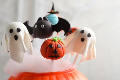 Photo of Different Halloween themed cake pops on light background, closeup