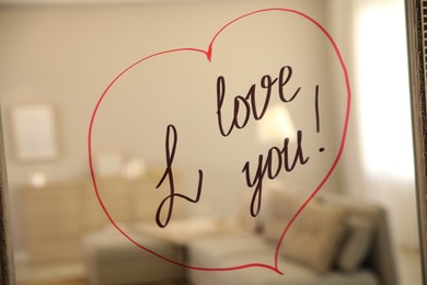 Drawn red heart with handwritten text I Love You on mirror in room. Romantic message