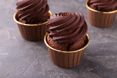 Photo of Delicious chocolate cupcakes on grey table, closeup