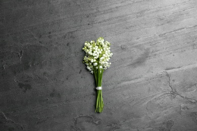 Photo of Beautiful lily of the valley bouquet on grey background, top view