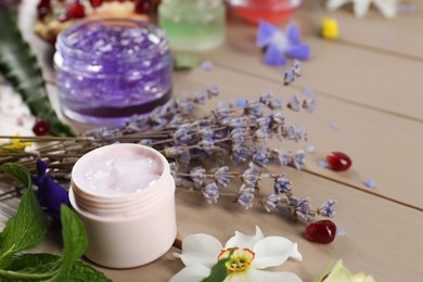 Photo of Homemade cosmetic products and fresh ingredients on wooden table, closeup. Space for text