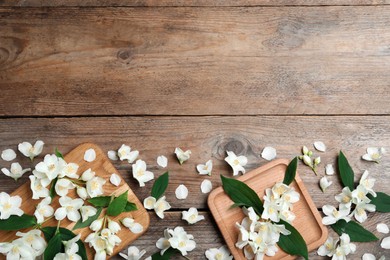 Flat lay composition with beautiful jasmine flowers on wooden background. Space for text