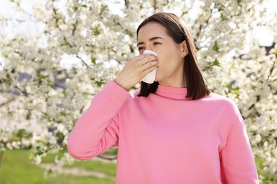 Photo of Woman with napkin suffering from seasonal allergy on spring day