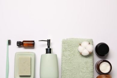 Photo of Bath accessories. Different personal care products and cotton flowers on white background, flat lay with space for text