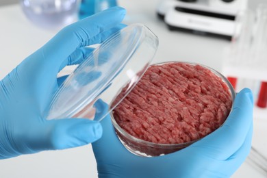Photo of Scientist holding Petri dish with raw minced cultured meat in laboratory, closeup