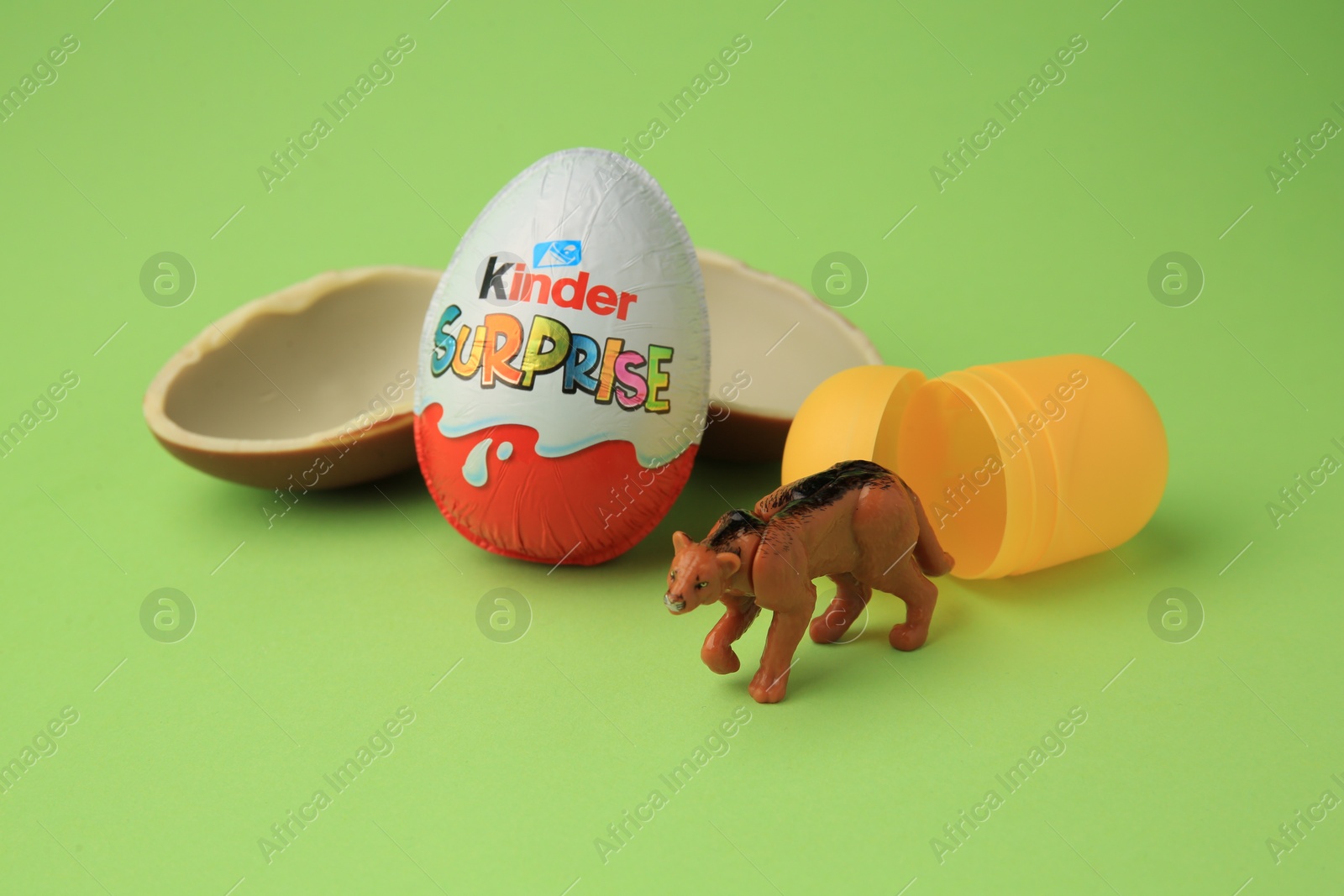 Photo of Sveti Vlas, Bulgaria - June 29, 2023: Kinder Surprise Eggs, plastic capsule and toy puma on light green background