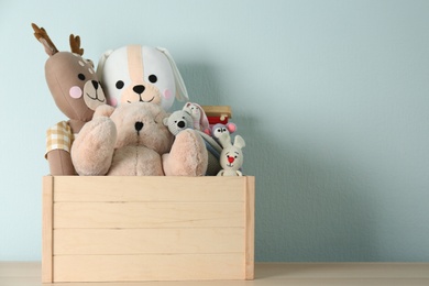 Crate with different toys on wooden table. Space for text