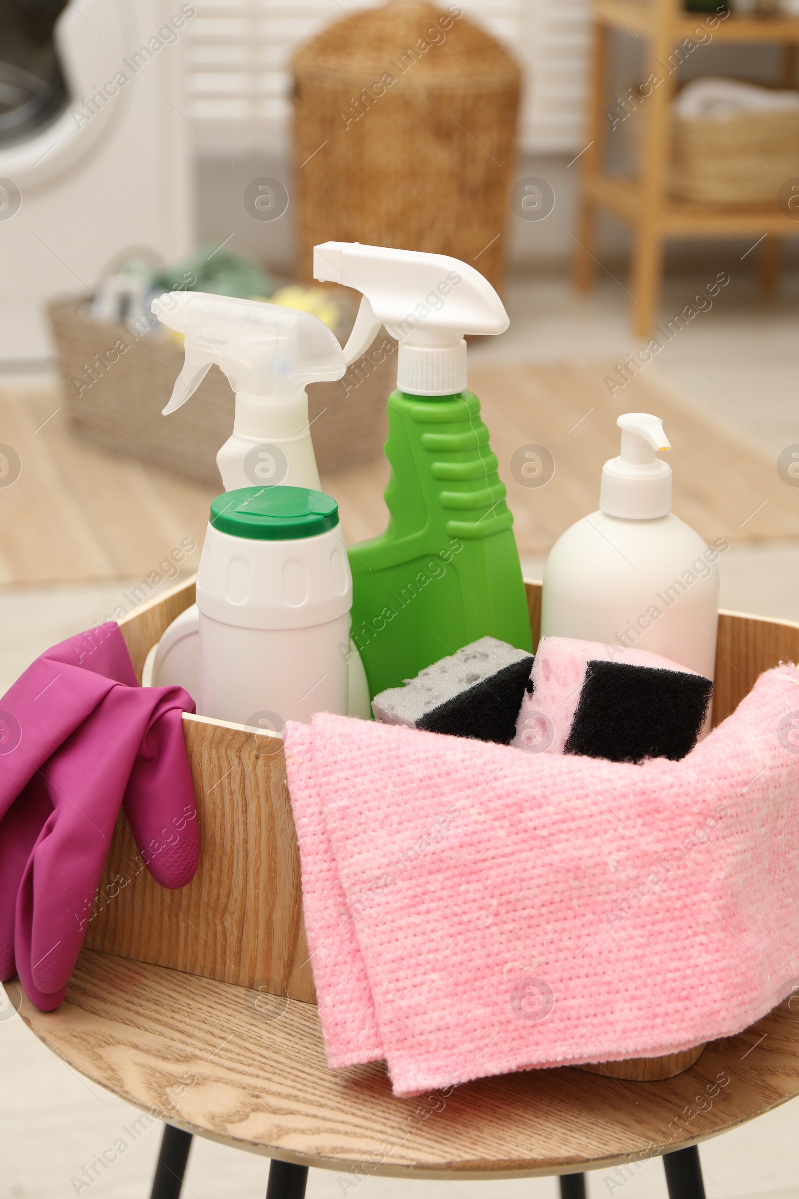 Photo of Different cleaning products in wooden box on table indoors