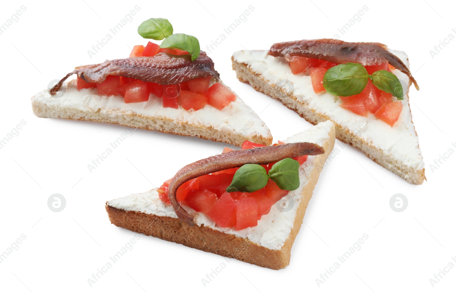 Photo of Delicious sandwiches with cream cheese, anchovies, tomatoes and basil on white background