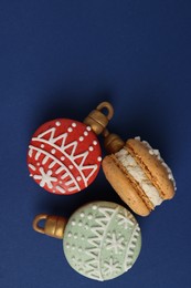 Photo of Beautifully decorated Christmas macarons on blue background, flat lay