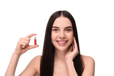 Beautiful young woman holding skincare ampoule on white background