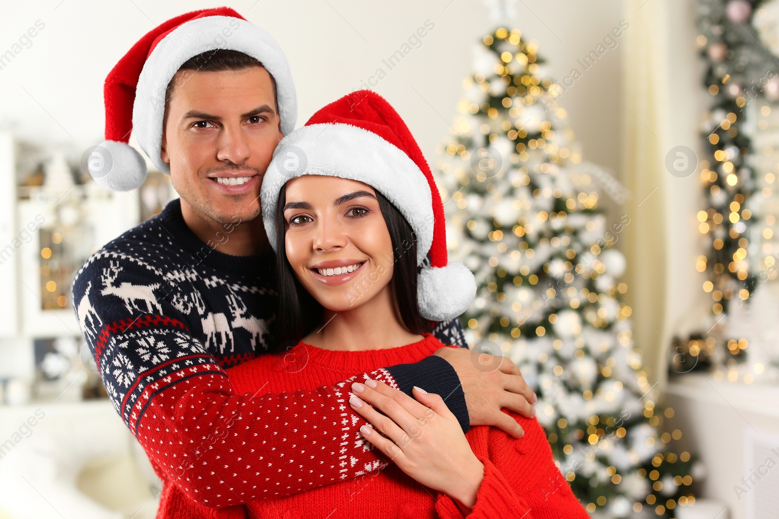 Photo of Happy couple in Santa hats at home. Christmas celebration