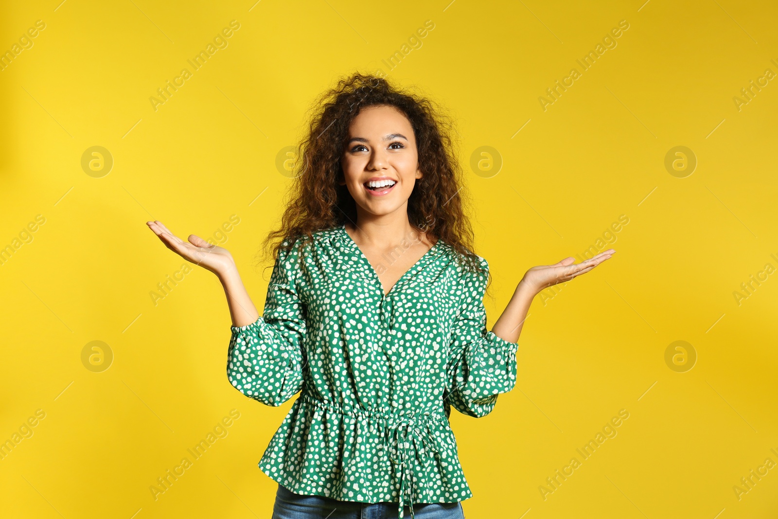Photo of Portrait of emotional African-American woman on color background