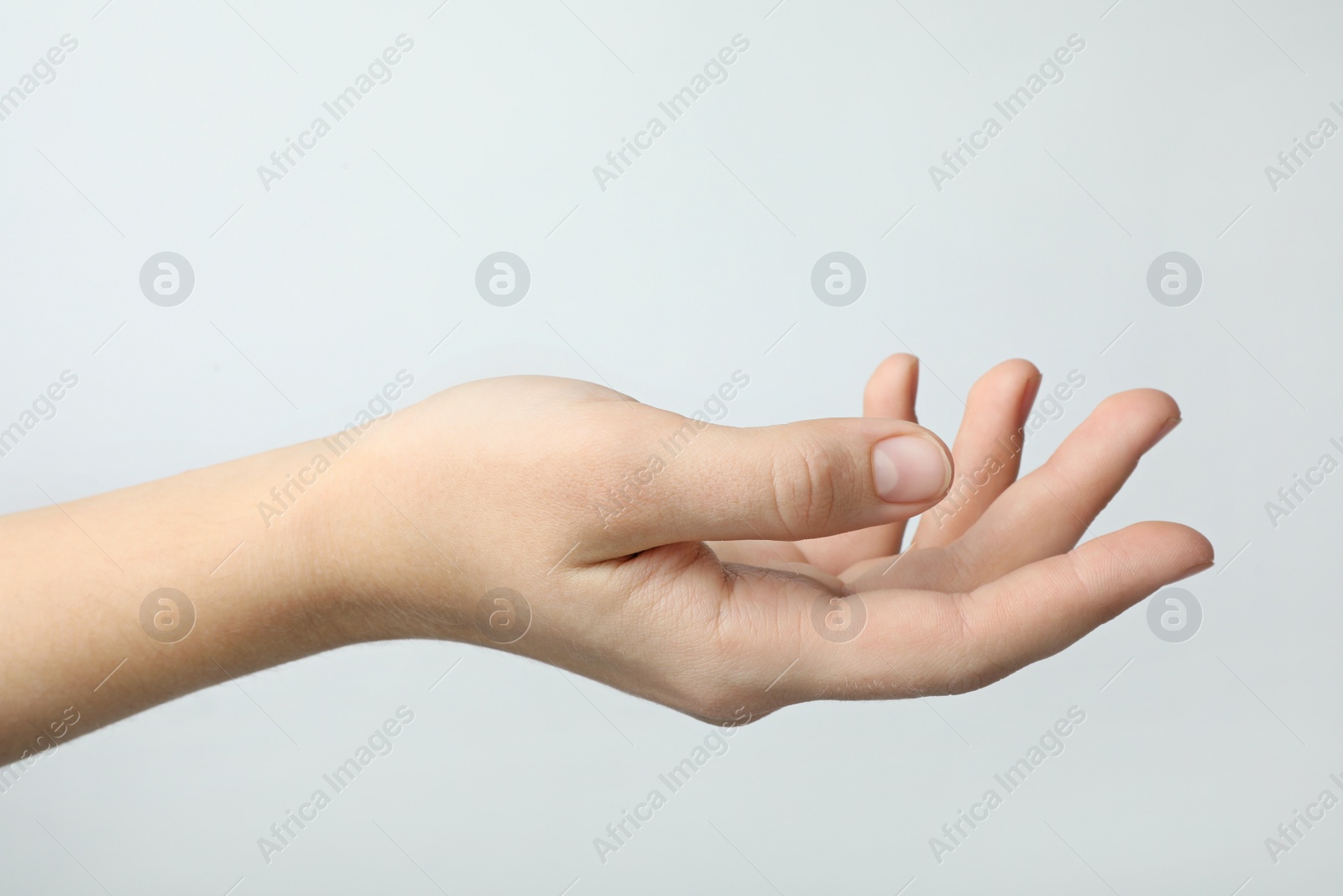 Photo of Woman holding something against light background, focus on hand
