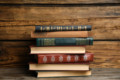 Collection of different books on table against wooden background